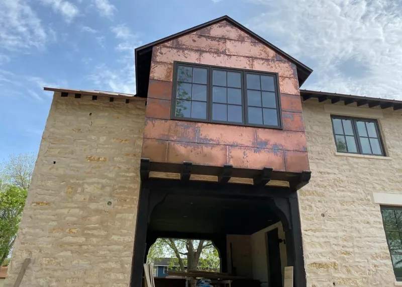 Copper metal panel facade on a stone building for Skylight Installation in Leawood